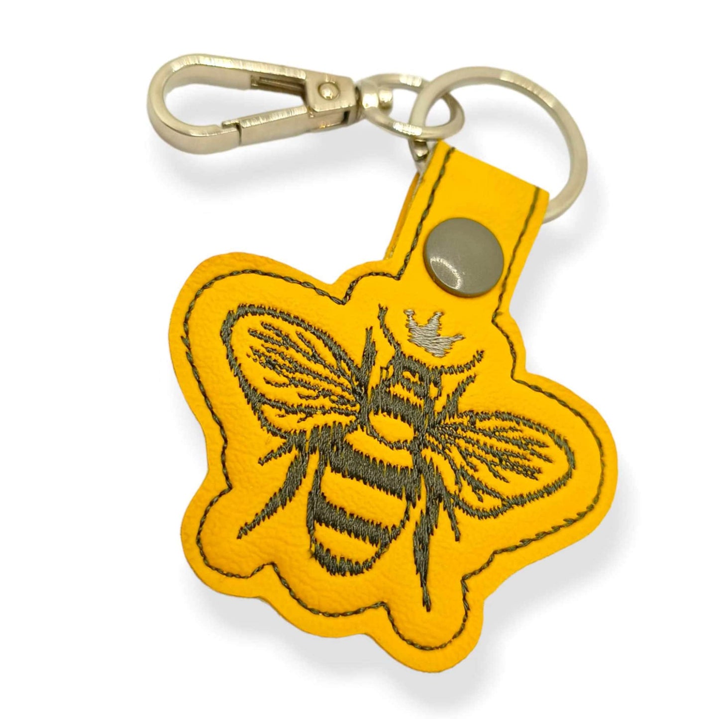 Yellow vinyl bee themed keychain on white background.